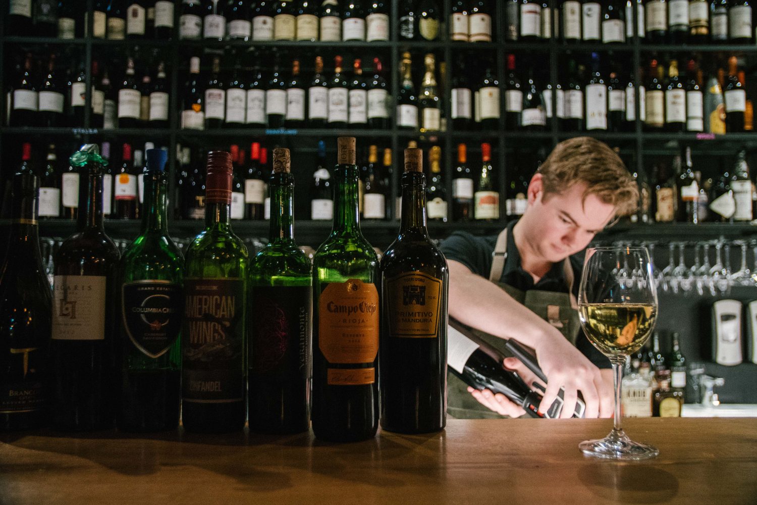 A barteder at Port 9 pouring wine.